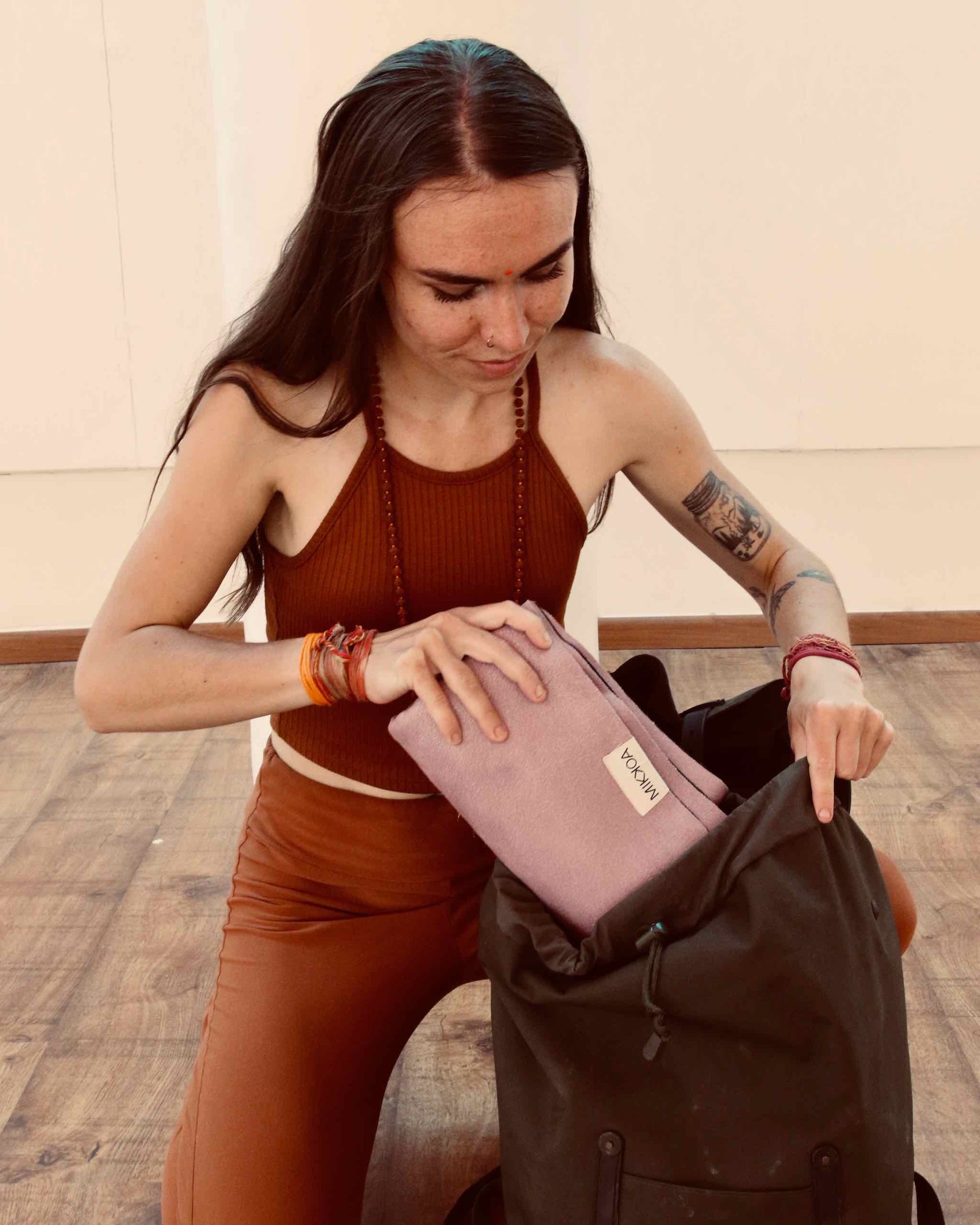 Portable Yoga Mat-Women Keeping Folded Yoga Mat In Bag Image-Mikkoa Melon Travel Yoga Mat